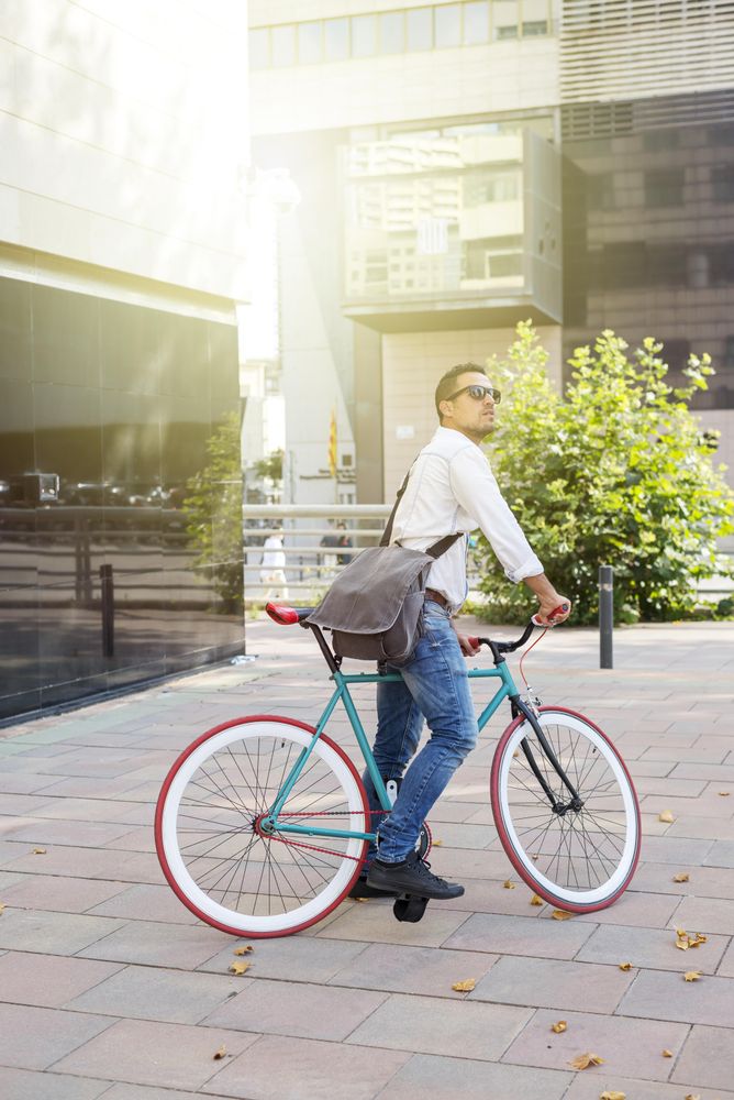 Male sitting on bike and looking around outside on sunny day