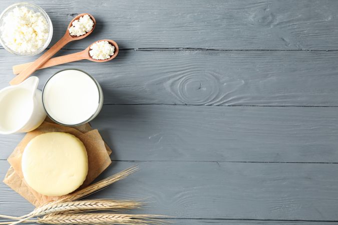 Flat lay. Different dairy products on grey wooden background, copy space