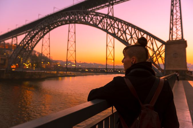 Woman looking at river and city in evening