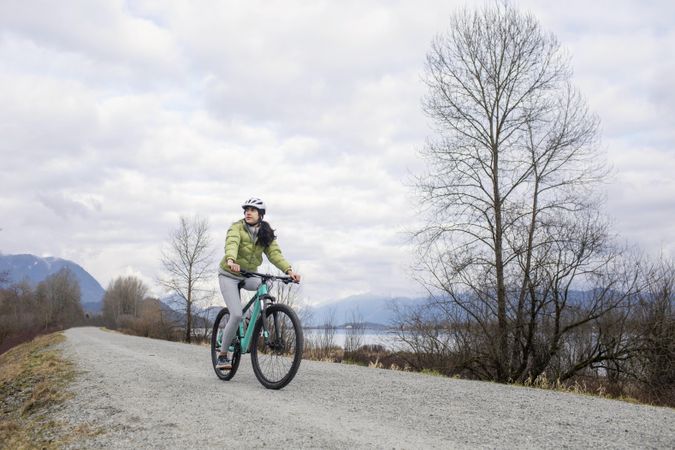 Young woman riding a bicycle around a lake