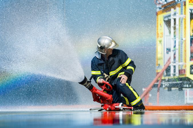 Anonymous fireman fighting fire with water