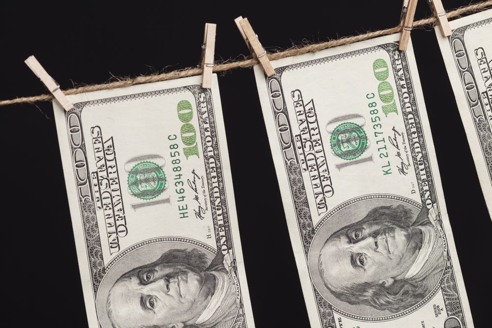 Hundred Dollar Bills Hanging From Clothesline on Dark Background