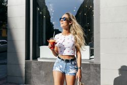 Stylish woman enjoying healthy drink on street