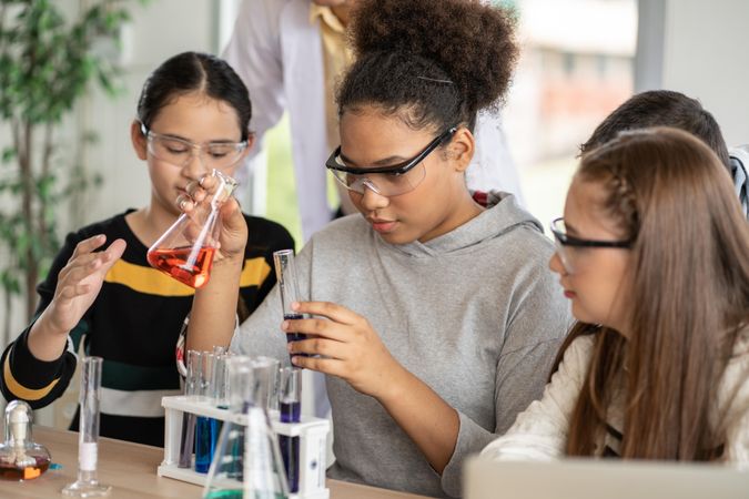 Group of female students in science class doing chemical experiment in laboratory