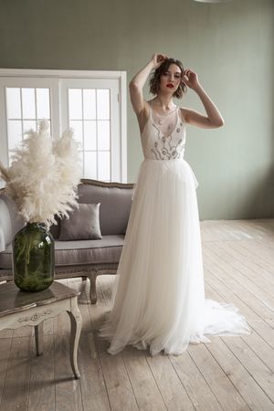 Young woman with red lips in elegant white dress looking at camera