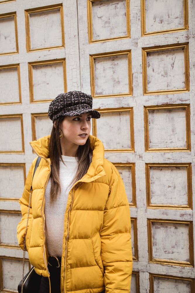 Stylish woman in yellow near shabby wall on street