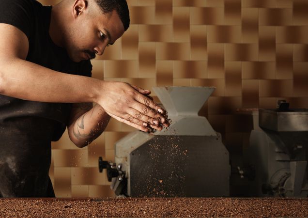 Black male chef sprinkling ground nuts on chocolate dessert