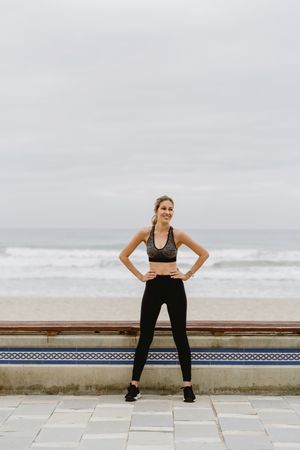 Woman in sports clothing stretching before exercise at seaside