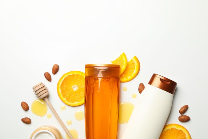 Bottles of cosmetics and natural ingredients on light background