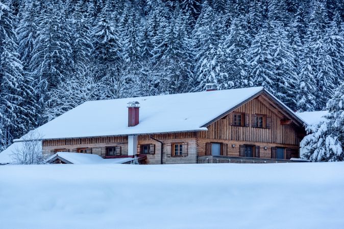 Log cabin covered in deep snow in December, in the Bavarian Alps, Germany