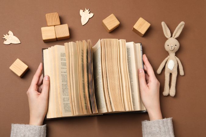A children's book with toys on a beige background.