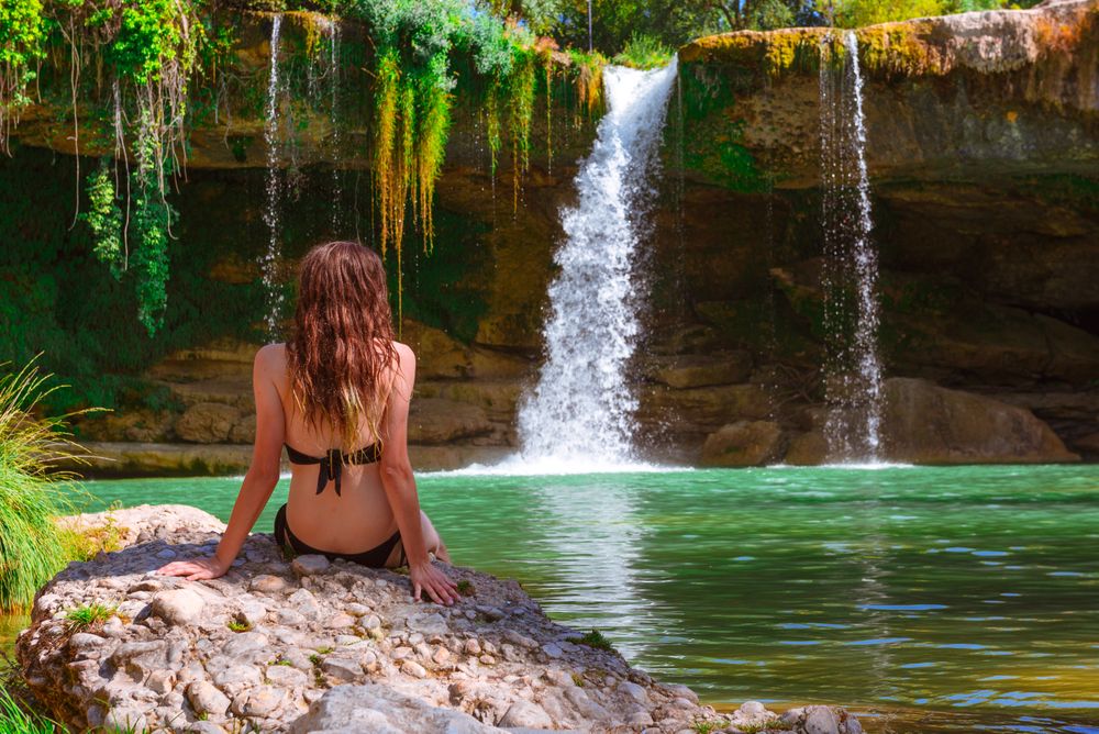 Young female relaxing near waterfall