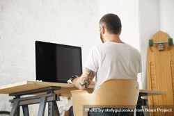 Man at computer in bright and modern home office 48LOj4
