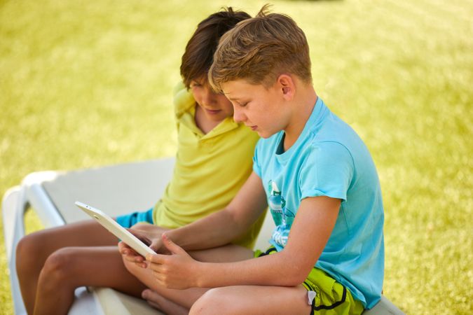 Boys using tablet in garden