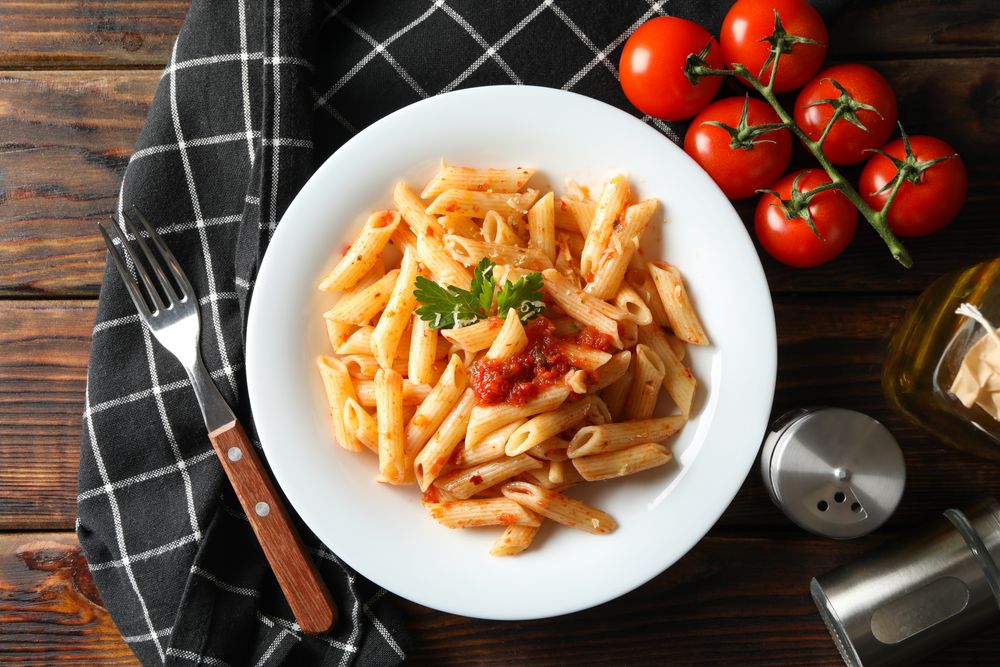 Composition with plate of tasty pasta on wooden background. Cooking pasta