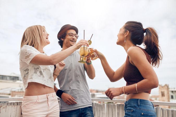 Outdoor shot of young people enjoying cocktails at a party