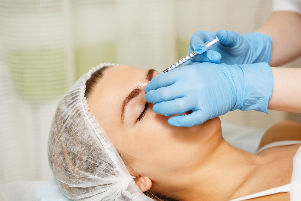 Cosmetologist at med spa injecting botox in female client