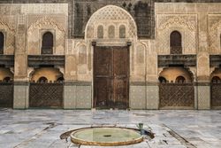 Big container with water near ancient building with vintage doors