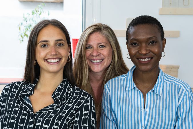 Cheerful diverse coworking women looking at camera