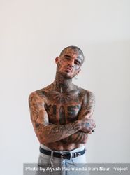 Shirtless Latino man in tough guy pose with full body and facial tattoos, shaved head and piercings 5ngwA4
