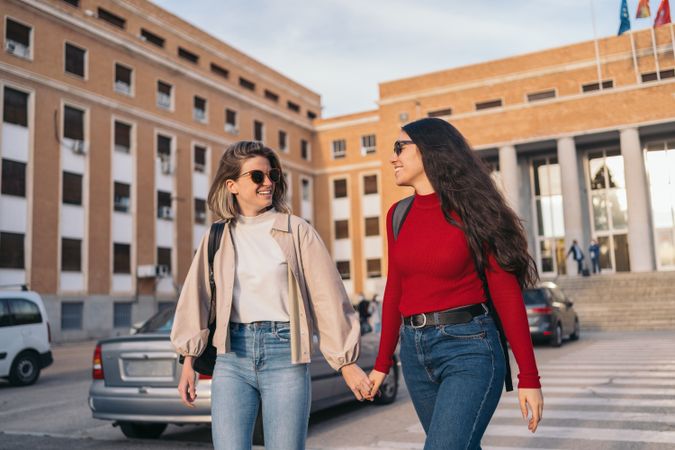 student couple in college holding hands. Blonde and brunette