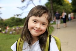Adorable little child wearing backpack and smiling at camera