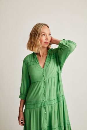 Blonde woman in green dress in studio