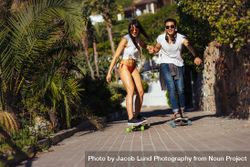 Cheerful friends doing skateboarding outdoors 4AeVQ4