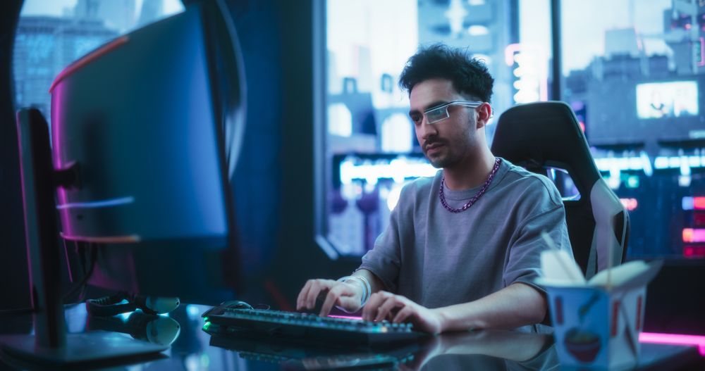 Creative Multiethnic Man Using Desktop Computer in a Futuristic High Tech Office Space.