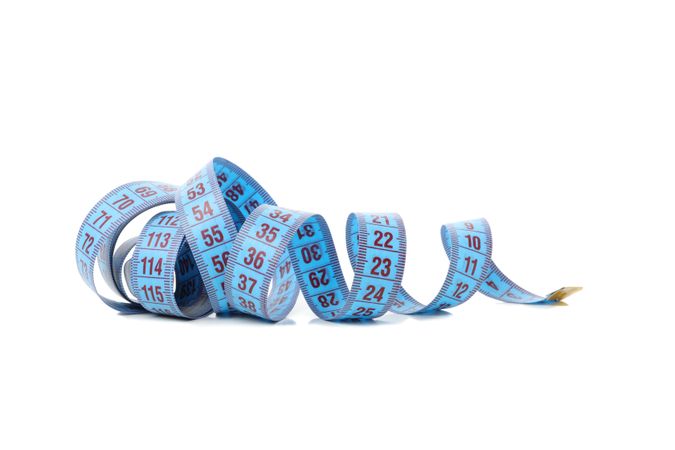 Measuring tape isolated on light background. Weight loss