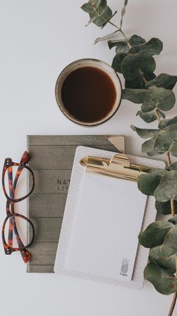 Writing accessories and drink in mug on white background