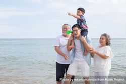Asian family walking on the beach together 49oov0