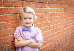 Cute Young Boy Portrait Against A Brick Wall