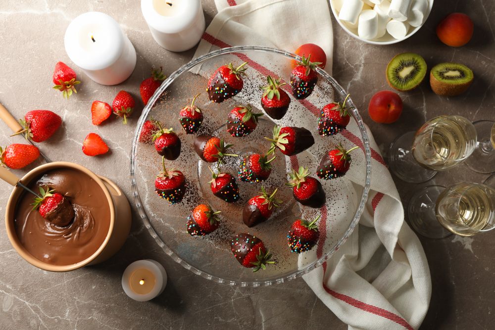 Composition with chocolate fondue on gray table. Delicious sweet food
