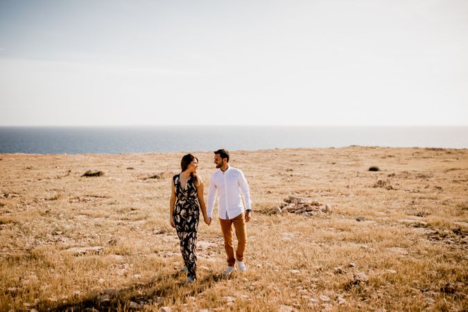 Peaceful lovers bonding on empty coastline