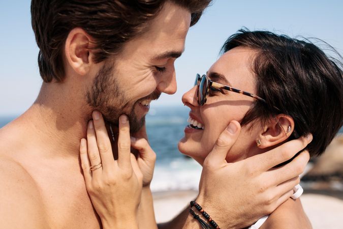 Couple holding each other to kiss standing on the beach