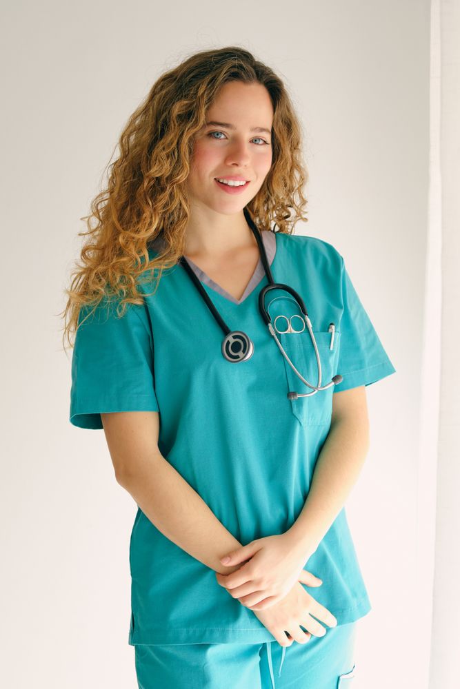 Smiling female doctor standing with crossed arms in room