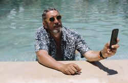 man using smartphone in swimming pool