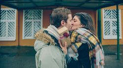 Couple kissing as woman receives a giftbox