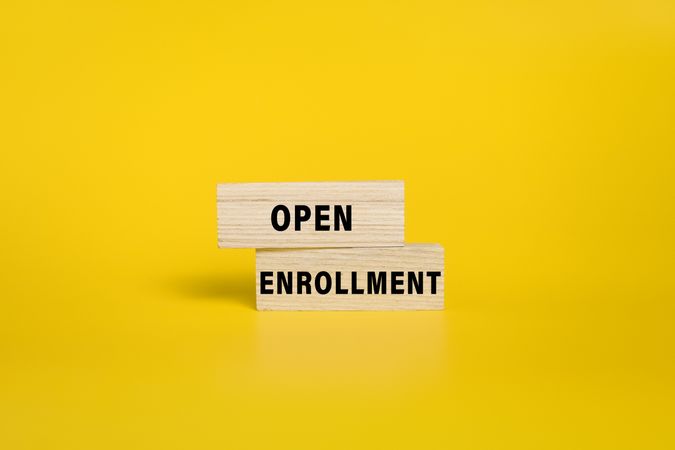 open enrollment words on wooden blocks isolated on yellow background