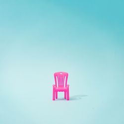 Pink outdoor chair on blue background