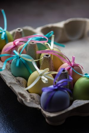 Carton of decorative pastel Easter eggs with ribbons