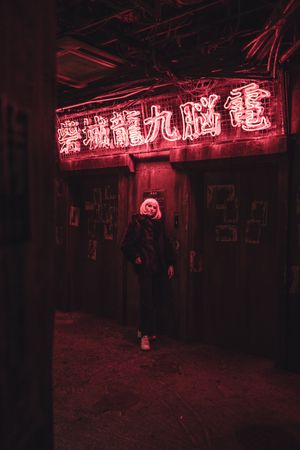 Woman standing under red neon signage