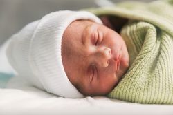 Newborn baby sleeping in crib. Babyhood concept.