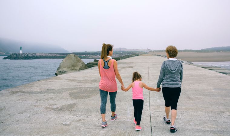 Back view of three female generations walking