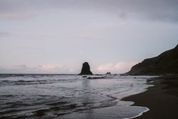 Lonely cliff in sea on cloudy day