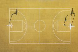 Young man playing basketball on outdoor court.