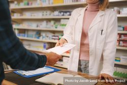Cropped shot of customer handing a prescription to the female pharmacist 5Qxqe0