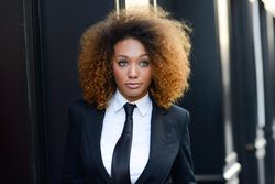 Female in suit outside adjusting standing on street with copy space