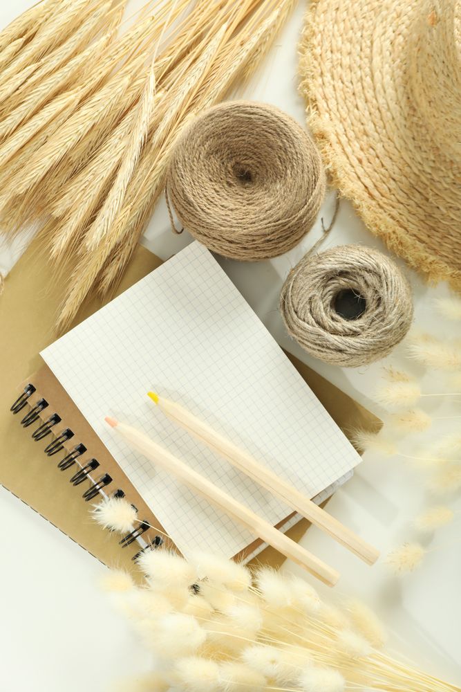 Looking down at table with notebook, pencils and willows, vertical